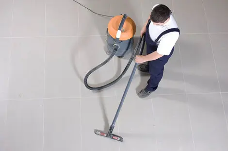 Man cleaning floor using vacuum cleaner
